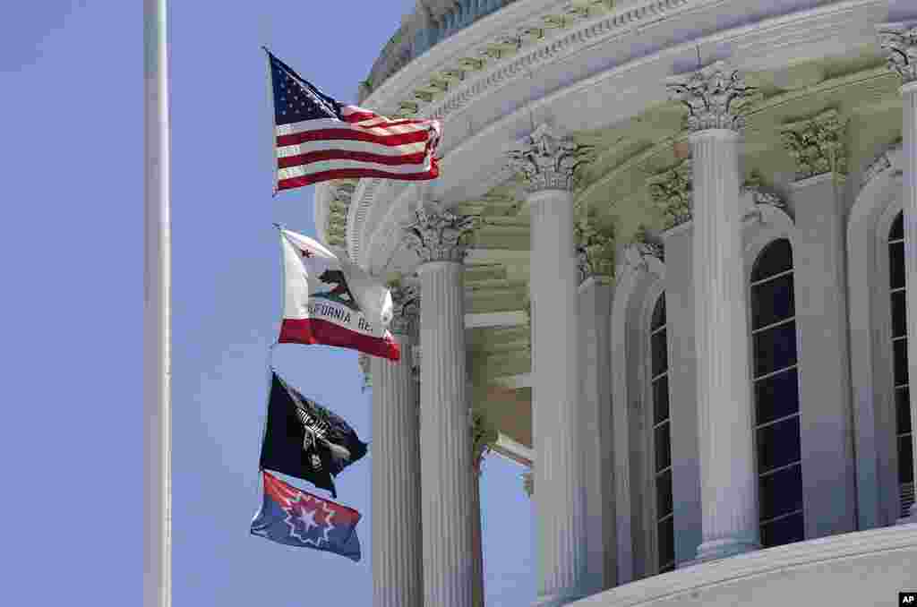 La bandera de Juneteenth ondea sobre el Capitolio de California, en Sacramento,&nbsp;entre la bandera estadounidense y la que honra a los prisioneros de guerra, el domingo 19 de junio de 2022.