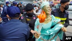 Cambodian-US human rights advocate Theary Seng, dressed as Lady Liberty, is arrested by police after being found guilty of treason in her trial in front of the Phnom Penh municipal court on June 14, 2022. (Photo by Samuel / AFP)