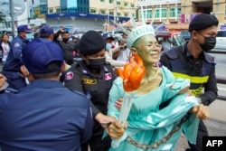 FILE - Cambodian-US human rights advocate Theary Seng, dressed as Lady Liberty, is arrested by police after being found guilty of treason in her trial in front of the Phnom Penh municipal court on June 14, 2022. (Photo by Samuel / AFP)