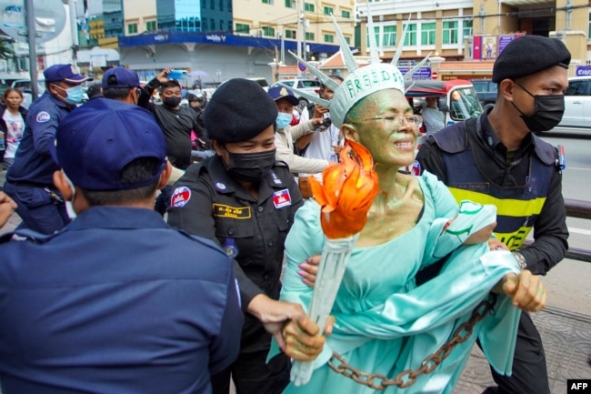 FILE - Cambodian-US human rights advocate Theary Seng, dressed as Lady Liberty, is arrested by police after being found guilty of treason in her trial in front of the Phnom Penh municipal court on June 14, 2022. (Photo by Samuel / AFP)