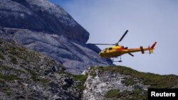 A helicopter participates in search and rescue operations at the site of a deadly collapse of parts of a mountain glacier in the Italian Alps, at the Dolomites' Marmolada ridge, Italy, July 5, 2022.