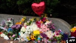 Un monumento improvisado se llena de flores en el lugar del tiroteo masivo de Highland Park, Illinois, el 4 de junio de 2022. Foto AFP.