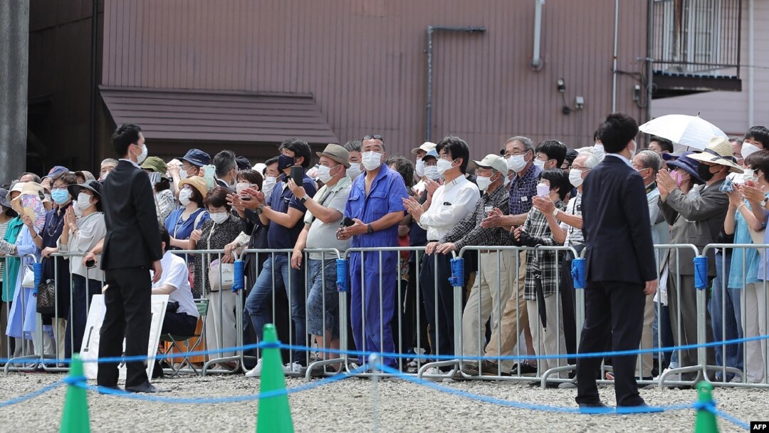 Voters listen to street speeches at an election campaign under strict security in Fujiyoshida City, Yamanashi prefecture on July 9, 2022 ahead of the polling day of the Upper House election on July 10.