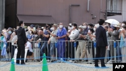 Voters listen to street speeches at an election campaign under strict security in Fujiyoshida City, Yamanashi prefecture on July 9, 2022 ahead of the polling day of the Upper House election on July 10.