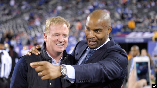 Former New York Giants defensive end Osi Umenyiora, right, talks with NFL commissioner Roger Goodell (right) before an NFL football game between the New York Giants and the San Francisco 49ers, Oct. 11, 2015