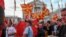 Supporters of North Macedonia's main opposition party VMRO-DPMNE wave party flags and national flags as they march during a rally in front of a government building in Skopje, June 18, 2022