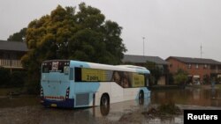A bus inundated by floodwaters sits in the middle of a residential street, following heavy rains and severe flooding in the McGraths Hill suburb of Sydney, July 6, 2022.