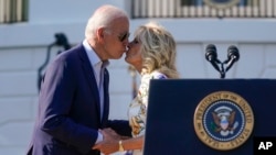 President Joe Biden kisses first lady Jill Biden after she introduced him to speak during a Fourth of July celebration for military families on the South Lawn of the White House, Monday, July 4, 2022, in Washington.