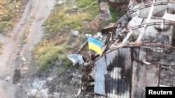 Ukrainian service members install a national flag on Snake (Zmiinyi) Island, as Russia's attack on Ukraine continues, in Odesa region, Ukraine, in this handout picture released July 7, 2022. (Press service of the Ukrainian Armed Forces/Handout via Reuters