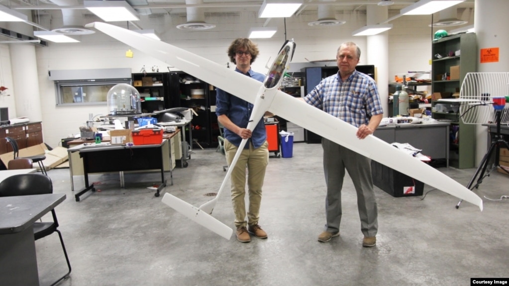 Aerospace engineering doctoral student Adrien Bouskela (left) and professor Sergey Shkarayev hold an experimental sailplane. The team hopes to one day send a version of a similar plane to Mars. (Image Credit: Emily Dieckman/College of Engineering)