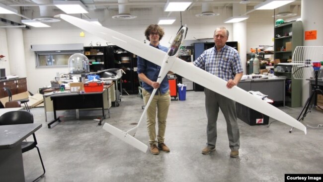 Aerospace engineering doctoral student Adrien Bouskela (left) and professor Sergey Shkarayev hold an experimental sailplane. The team hopes to one day send a version of a similar plane to Mars. (Image Credit: Emily Dieckman/College of Engineering)