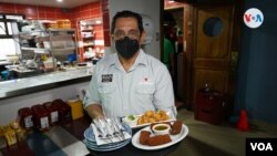 El doctor Rommel Meléndez trabaja actualmente en un restaurante en Costa Rica. [Foto: Houston Castillo, VOA]