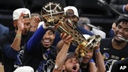 Stephen Curry, de los Warriors de Golden State, levanta el trofeo Larry O'Brien, luego de ganar las Finales de la NBA a los Celtics de Boston, el jueves 16 de junio de 2022 (AP Foto/Michael Dwyer)
