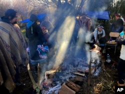Members of the Mapuche Indigenous community gather while cooking a barbecue during celebrations of the Wetripantu or Mapuche New Year, in Corrayen village, Puyehue district, Chile, in this Tuesday, June 21, 2022 iPhone photo, taken by Rodrigo Abd. (AP Photo/Rodrigo Abd)