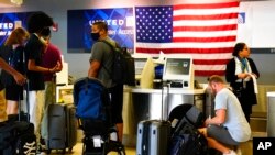 Travelers check in at the Philadelphia International Airport ahead of the Independence Day holiday weekend July 1, 2022. 
