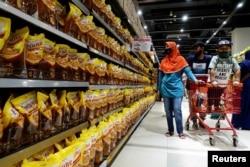 Deretan minyak goreng dari kelapa sawit yang dijual di sebuah supermarket di Jakarta, 27 Maret 2022. (REUTERS/Willy Kurniawan)