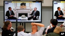 Sejumlah wartawan melihat layar yang menampilkan pertemuan antara Presiden Joko Widodo dan Presiden Rusia Vladimir Putin di Kremlin, Moskow, pada 30 Juni 2022. (Foto: AP/Alexander Zemlianichenko)