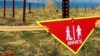 FILE - An international sign warning about mines hangs beside a minefield at Bagram Air Base on, March 22, 2002. The United States will soon provide antipersonnel mines to Ukraine, a U.S. official confirmed late Nov. 19, 2024.