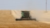 A farmer uses a combine harvester to harvest wheat on a field near Izmail, in the Odessa region, on June 14, 2022, amid the Russian invasion of Ukraine.
