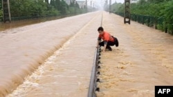 中国江西上饶一名铁路工人在暴雨后检查被洪水淹没的铁轨情况。（2022年6月21日）