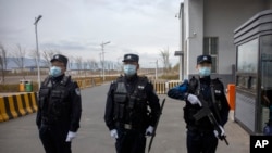 Petugas polisi berdiri di pintu masuk luar Pusat Penahanan Urumqi No. 3 di Dabancheng di Daerah Otonomi Uyghur Xinjiang China barat pada 23 April 2021. (Foto: AP)