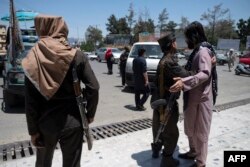 Seorang pejuang Taliban menggeledah pejalan kaki di sepanjang jalan yang diblokir menjelang pertemuan dewan pemimpin suku dan agama di Kabul, 29 Juni 2022. (Wakil KOHSAR / AFP)