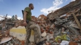 A Ukrainian soldier looks at the rubble of a school destroyed a few days ago during a missile attack, outside Kharkiv, Ukraine, on July 5, 2022. (AP Photo/Andrii Marienko)