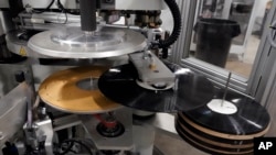 Piringan hitam baru dicetak menggunakan mesin pencetak di fasilitas United Record Pressing, Nashville, Tennessee, pada Kamis, 23 Juni 2022. (Foto: AP)