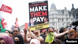 Demonstrators march in a trades union organised protest opposed to British government policies at Parliament Square in London, Britain, June 18, 2022. 