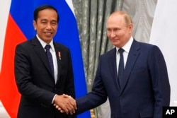 Presiden Rusia Vladimir Putin, kanan, dan Presiden Indonesia Joko Widodo berjabat tangan setelah konferensi pers bersama usai pertemuan mereka di Kremlin di Moskow, 30 Juni 2022. (Foto: AP)