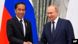 Russian President Vladimir Putin, right, and Indonesian President Joko Widodo shake hands after a joint news conference after their meeting in the Kremlin in Moscow, June 30, 2022.