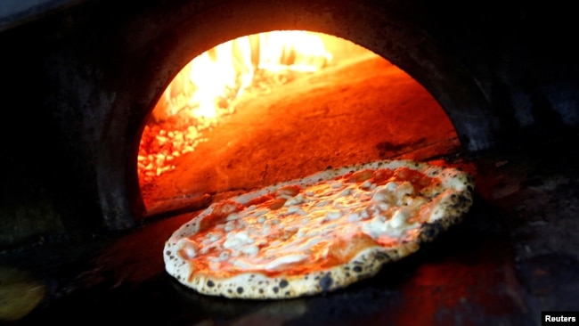 FILE - Pizza Margherita is prepared in a wood-fired oven at L'Antica Pizzeria da Michele in Naples, Italy December 6, 2017. (REUTERS/Ciro De Luca/File Photo)