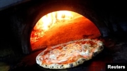 FILE - Pizza Margherita is prepared in a wood-fired oven at L'Antica Pizzeria da Michele in Naples, Italy December 6, 2017. (REUTERS/Ciro De Luca/File Photo)