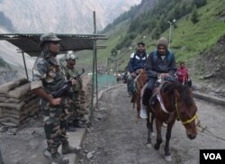 Indian security guards keep vigil as pilgrims cross mountain trails during their journey to the holy Amarnath cave in India. (Photo by Wasim Nabi)