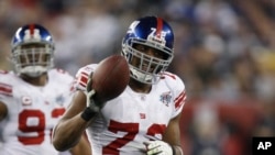 FILE - In this Feb. 3, 2008, file photo, New York Giants defensive end Osi Umenyiora (72) holds up the ball after a fumble recovery in the second quarter during Super Bowl XLIl.