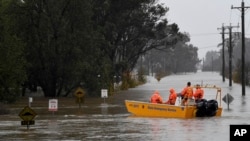 A New South Wales State Emergency Service (SES) crew is seen in a rescue boat as roads are submerged under floodwater from the swollen Hawkesbury River in Windsor, northwest of Sydney, July 4, 2022.