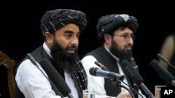 Zabiullah Mujahid, left, the spokesman for the Taliban government, speaks during a press conference in Kabul, Afghanistan, June 30, 2022.