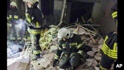 In this photo provided by the Ukrainian Emergency Service, first responders work a damaged residential building in Odesa, Ukraine, July 1, 2022, following Russian missile attacks.