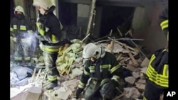 In this photo provided by the Ukrainian Emergency Service, first responders work at a damaged residential building in Odesa, Ukraine, July 1, 2022, following a Russian missile strike.