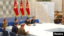김정은(가운데) 북한 국무위원장이 지난 2022년 노동당 중앙군사위원회 확대회의에 참석하고 있다. 한국 동해안 축선이 그려진 작전지도가 배경에 걸려있다. (자료사진)