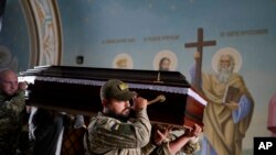 Soldiers carry the coffin of activist and soldier Roman Ratushnyi for his memorial service in Kyiv, Ukraine, June 18, 2022.