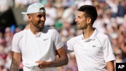 Serbia's Novak Djokovic, right, celebrates beating Australia's Nick Kyrgios in the final of the men's singles on day fourteen of the Wimbledon tennis championships in London, July 10, 2022.