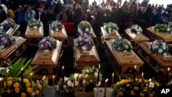 Deretan peti jenazah pada upacara pemakaman 21 remaja yang meninggal dalam tragedi misterius di klub malam hampir dua minggu lalu di Scenery Park, London Timur, Afrika Selatan, Rabu, 6 Juli 2022. (AP)