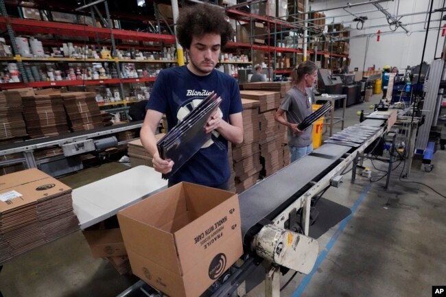 Elijah Lindsay loads finished vinyl records into shipping boxes at the United Record Pressing facility Thursday, June 23, 2022, in Nashville, Tenn. Vinyl record manufacturers are rapidly rebuilding an industry to keep pace with sales that topped $1 billio