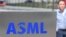 资料照：一名员工走过世界最大半导体制造机器供应商、位于费尔德霍芬的荷兰阿斯麦公司（ASML）总部的标识。（2018 年4月17日）