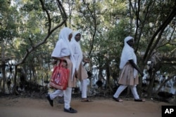 Anak-anak sekolah berjalan melewati pohon bakau di Vanga, Kabupaten Kwale, Kenya, Senin, 13 Juni 2022. (AP/Brian Inganga)