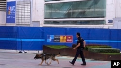 A police officer patrols with a sniffer dog outside the NATO Summit building ahead of next week's summit in Madrid, Spain, June 25, 2022.