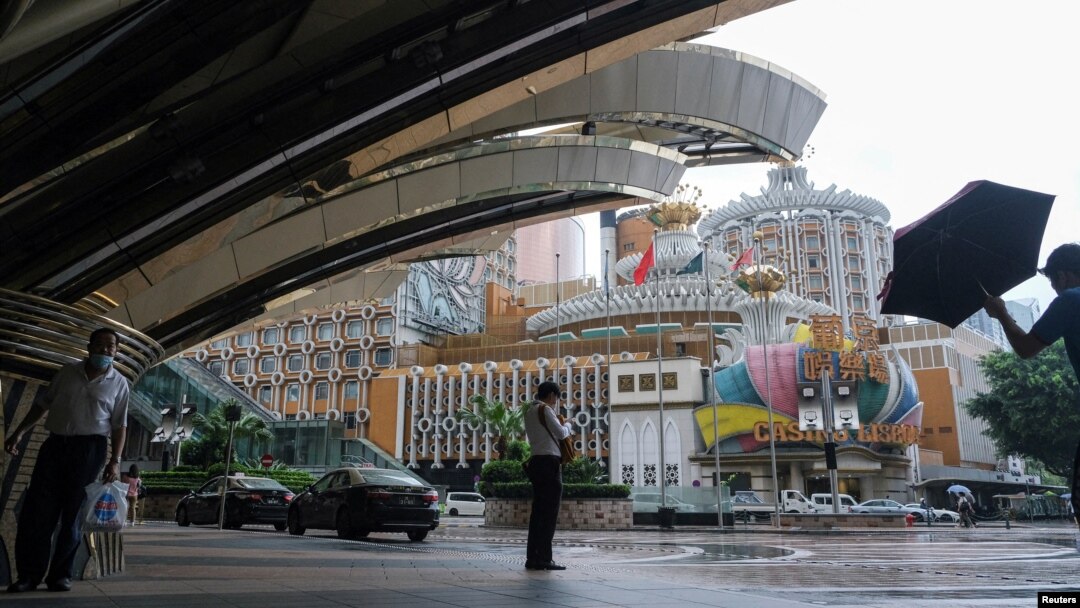 Orang-orang berdiri di dekat Casino Lisboa, di tengah wabah COVID-19, di Makau, China, 4 Juli 2022. (Foto: REUTERS/John Mak)