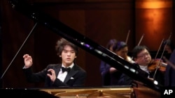 In this photo provided by The Cliburn, Yunchan Lim, of South Korea, performs a concerto with the Fort Worth Symphony Orchestra conducted by Chairman of the Jury Marin Alsop in the final round of the 16th Van Cliburn International Piano Competition at Bass