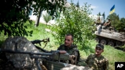 FILE - Ukrainian government soldiers guard a checkpoint outside Siversk, Donetsk region, Ukraine, July 12, 2014. Russian-backed proxy forces launched a campaign to take over the Donbas in 2014; now, Ukrainian troops are preparing to defend a new front lin